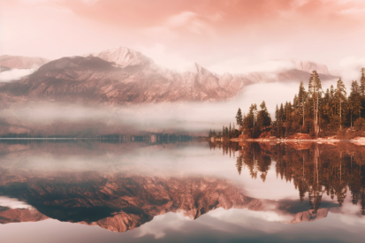 A lake with trees and mountains in the background