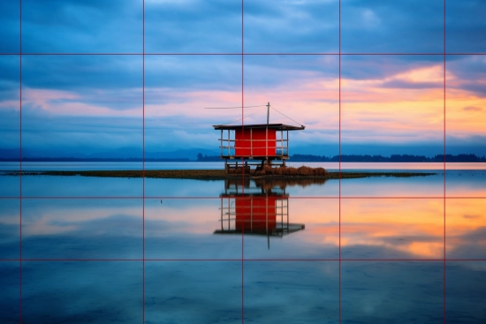 A small house on a small island in the middle of a body of water