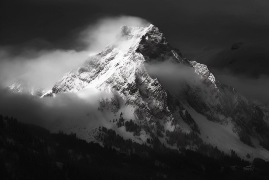 A mountain with snow and clouds